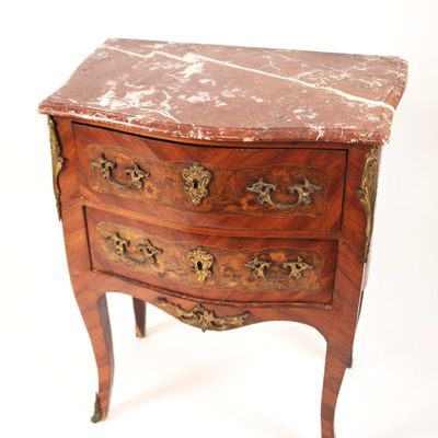 a marble top chest of drawers on a small table