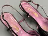 pair of chanel black and pink shoes on a grey surface