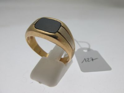 l'image d'une bague en or ornée d'une pierre noire