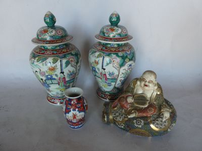 three asian vases and a buddha statue on a table
