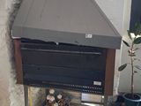 a small oven sitting in the corner of a room next to a potted plant