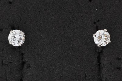 une paire de boucles d'oreilles en diamant posée sur une surface noire