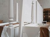 a pile of white furniture in a room with a brick wall