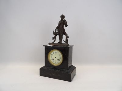 une petite horloge sur laquelle sont représentés un homme et un chien