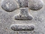 a stone carving of a face on the side of a building