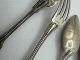 four forks and a spoon on a white table