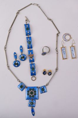 un collier, des boucles d'oreilles et une bague, présentés sur un fond blanc