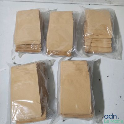 six sacs en papier kraft sont posés sur une surface blanche