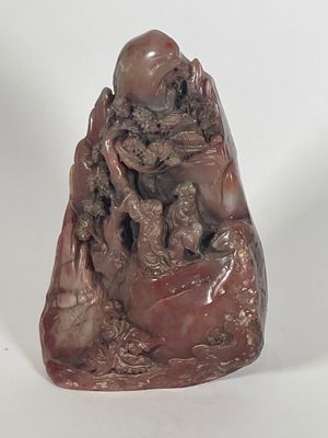 statue of a man sitting on a rock holding a baby