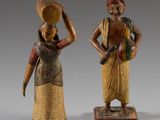 trois figurines en bois représentant des femmes portant des paniers sur la tête