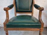 an image of a green leather chair sitting on top of a cement floor