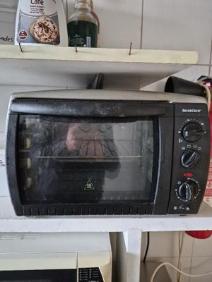 un four grille-pain posé sur une étagère dans une cuisine