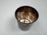 a silver cup with a spoon in it on a table