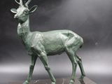 a bronze sculpture of a deer on a marble base