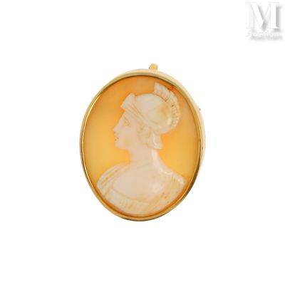 un gros plan sur le portrait d'une femme représenté sur une broche en or