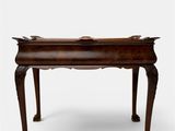 an old wooden table with a carved top and legs