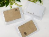 two small white tags with a small brown tag on them