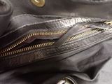 a close up of a black purse with gold zippers