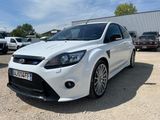 the white ford focus is parked in a lot with other cars in the background