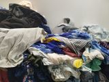 a pile of clothes sitting on the floor next to a wall