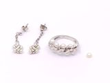deux bagues et une paire de boucles d'oreilles posées sur une surface blanche