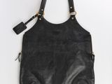 un sac à main en cuir noir accroché à un mur blanc