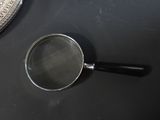 a magnifying glass sitting on a table next to a mirror