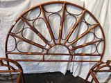 a rattan headboard and two chairs in front of a white sheet