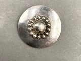 un bouton en métal orné d'une multitude de perles