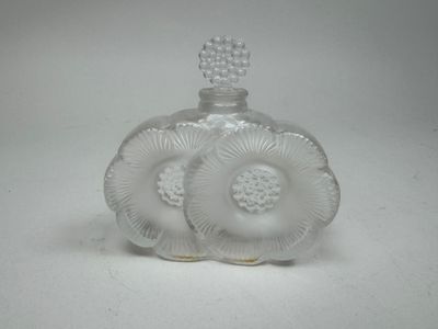 une petite bouteille en verre ornée d'un motif floral