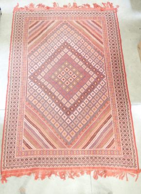 un tapis orange et rose posé sur un sol blanc