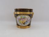 a small vase with flowers on it sitting on a table