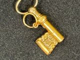 a gold key that is sitting on a black surface