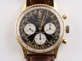 une montre en or avec un cadran noir et un bracelet en cuir marron