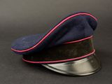 navy blue hat with red trim on a metal base on a black background