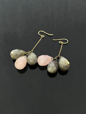 a pair of pink and green stone earrings on a black surface