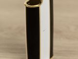 a black and white cigarette lighter sitting on top of a wooden table
