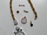 un gros plan sur une chaîne en or ornée d'une montre et d'autres objets