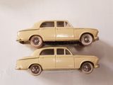 two toy cars that are sitting on a white surface