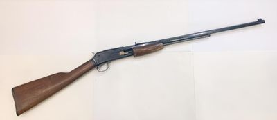 a shotgun with a wooden handle on a white surface