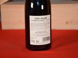 a bottle of wine sitting on a table next to a wooden box