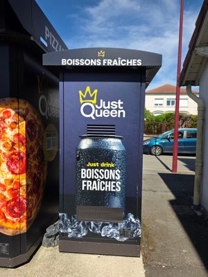 deux pizzas posées au bord de la rue, à côté d'une poubelle