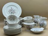 beaucoup d'assiettes et de tasses posées sur la table
