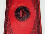 an old red book with a black border and a monogram on it