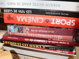 many books stacked on top of each other on a table