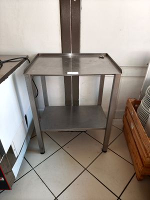 une table en métal avec une étagère, dans une cuisine