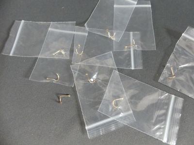 plusieurs morceaux de sacs en plastique transparent posés sur une table, à côté d'une paire de ciseaux