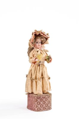 une figurine représentant une femme en robe et avec un chapeau
