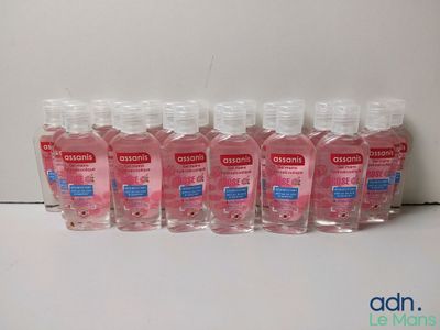 six flacons de gel hydroalcoolique sont alignés sur une étagère