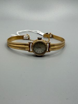 bracelet avec une montre dorée sur fond blanc